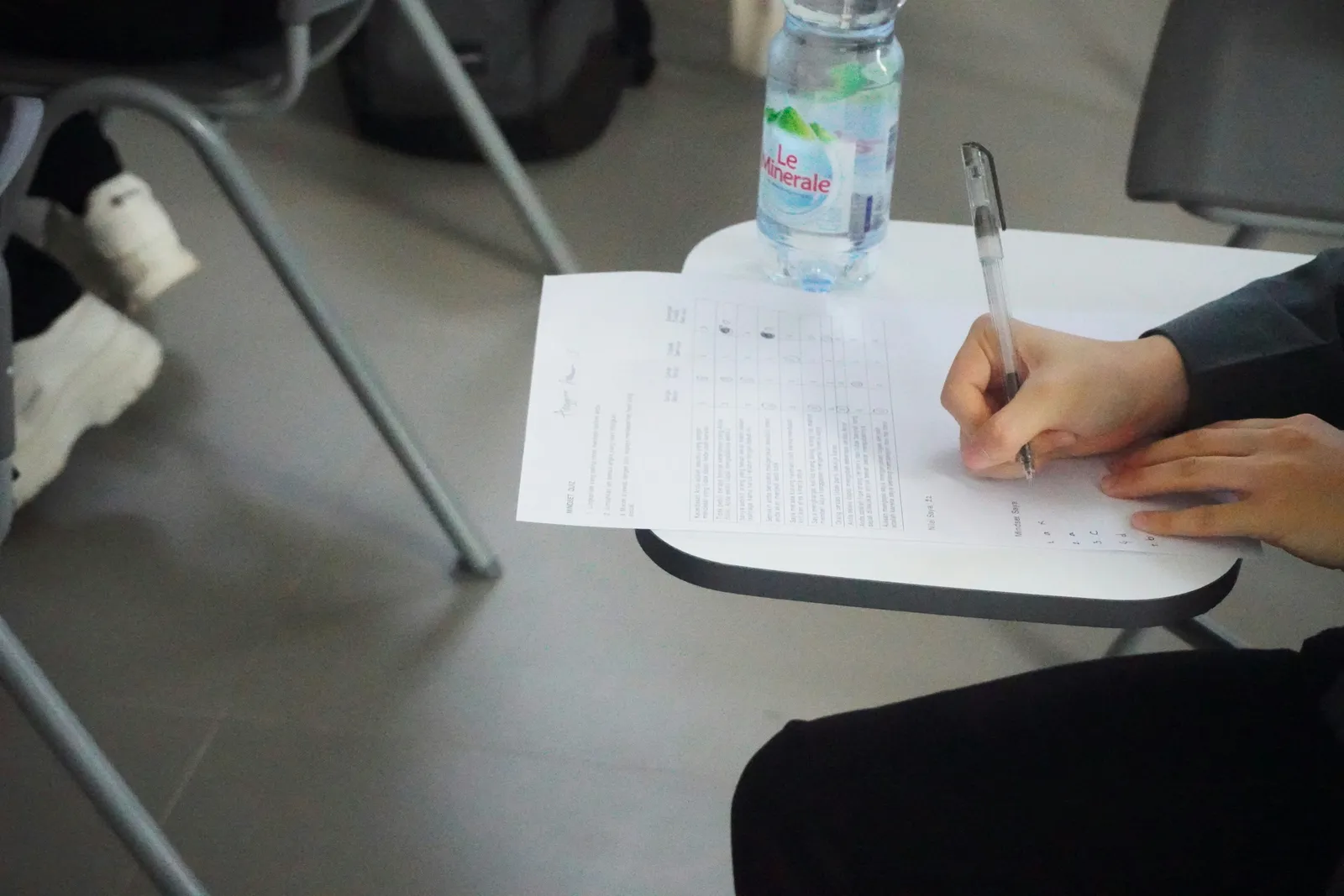 a person answering a handwritten exam on paper